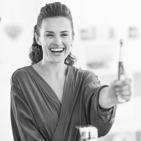 Happy young woman showing toothbrushの写真素材