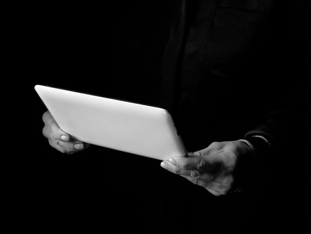 Black Mania. woman hands isolated on black using tablet PCの写真素材