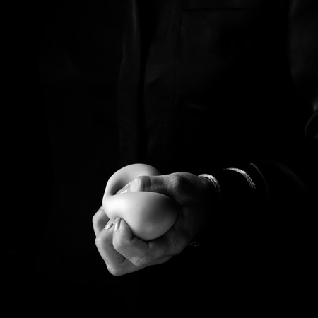 Black Mania. woman hand isolated on black using anti stress ballの写真素材