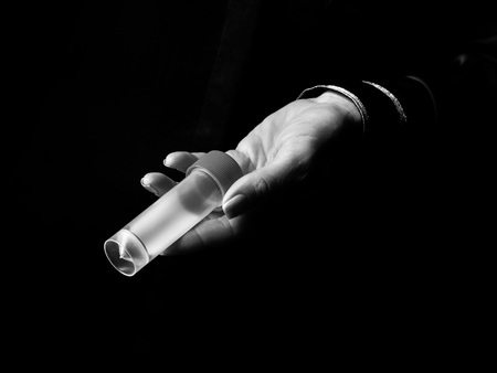 Black Mania. woman hand isolated on black showing sample jarの写真素材