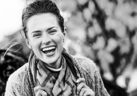 young laughing brunette woman relaxing in beautiful evening in autumn parkの写真素材