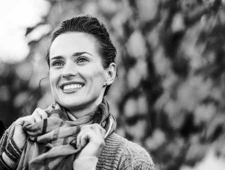 Portrait of happy young woman in autumn outdoors in eveningの写真素材