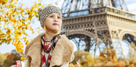 Having fun time near the world famous landmark in Paris. elegant girl on embankment near Eiffel tower in Paris, France looking into the distance while sitting on the parapetの写真素材
