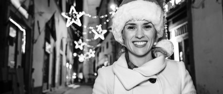 Trip full of inspiration at Christmas time in Florence. smiling young woman in Christmas hat  in Florence, Italyの写真素材