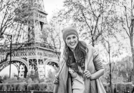 Autumn getaways in Paris. Portrait of smiling young elegant woman near Eiffel tower in Paris, Franceの写真素材