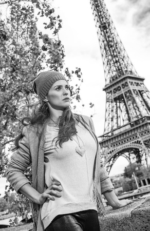 Autumn getaways in Paris. young elegant woman on embankment in Paris, France looking into the distanceの写真素材