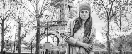 Autumn getaways in Paris. Portrait of young woman in Paris, France standing in front of Eiffel towerの写真素材