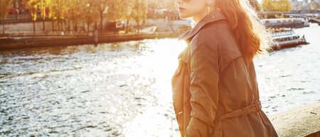 Autumn getaways in Paris. Closeup on young elegant woman in sunglasses on embankment near Eiffel tower in Paris, France looking into the distanceの写真素材