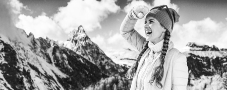 Winter on higher level of fun. happy young woman in the front of mountain landscape in Alto Adige, Italy looking into the distanceの写真素材