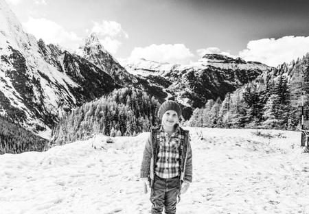 Winter on higher level of fun. Portrait of happy modern girl in the front of mountain landscape in Alto Adige, Italyの写真素材