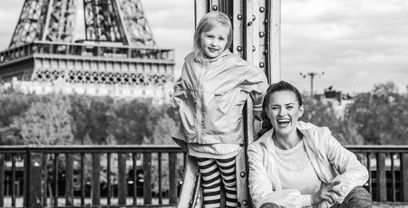 Year round fit & hip in Paris. Full length portrait of smiling healthy mother and daughter in sport style clothes on Pont de Bir-Hakeim bridge in Parisの写真素材