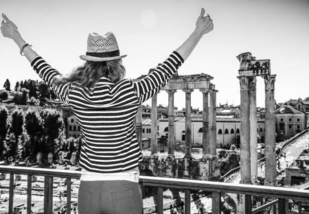 Roman Holiday. Seen from behind young tourist woman near Roman Forum in Rome, Italy rejoicingの写真素材