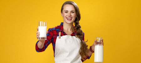 Healthy food to your table. Portrait of smiling modern woman cook wearing apron isolated on yellow...