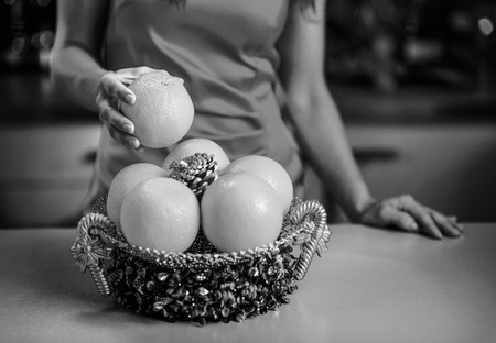 Closeup on young housewife taking orangeの写真素材