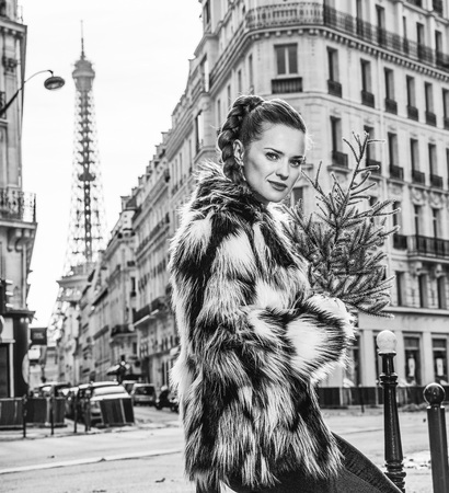 Boiling hot trendy winter in Paris. Portrait of trendy woman with Christmas tree in Paris, Franceのeditorial素材