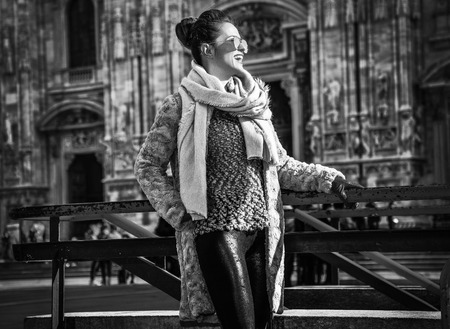 Rediscovering things everybody love in Milan. happy trendy tourist woman in fur coat and sunglasses in Milan, Italy looking into the distanceの写真素材
