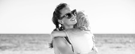 Colorful and wonderfully cheerful mood. happy modern mother and daughter in colorful clothes on the beach huggingの写真素材