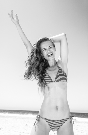 Blue sea, white sand paradise. cheerful young woman with long brunette hair in beachwear on the beach having fun timeの写真素材