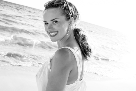 wonderfully cheerful mood. happy modern woman in dress on the beach in the eveningの写真素材