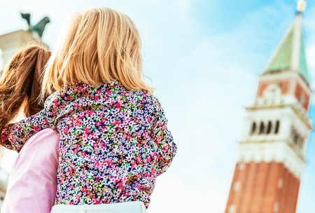 Mother and baby looking on campanile di san marco in venice, italyの写真素材
