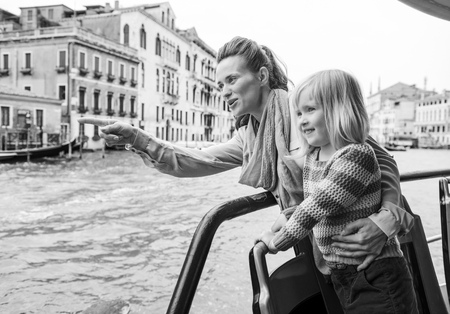 Baby girl and mother poiting while travel by vaporetto in venice, italyの写真素材