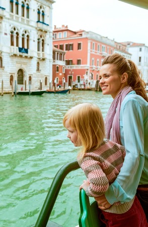 Mother and baby girl travel by venice water busの写真素材
