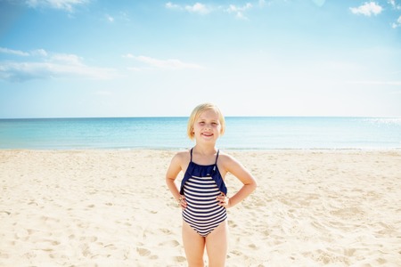 Portrait of happy child in swimsuit standing on the seashoreの写真素材
