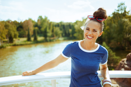 smiling modern tourist woman in blue t-shirt on river boat having river voyage.の写真素材