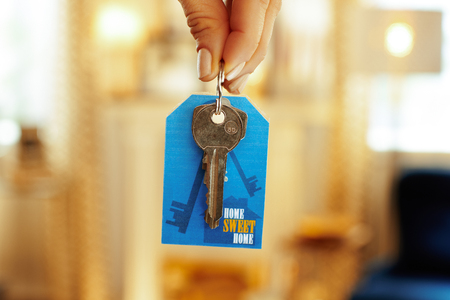 Closeup on door keys with label in hand of modern woman in the house.の写真素材