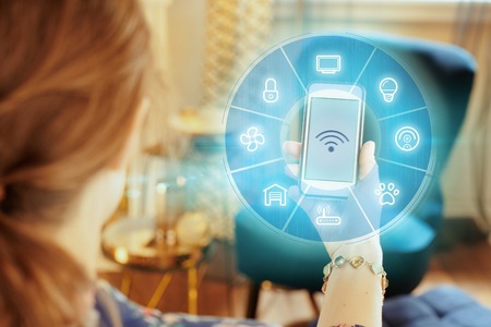 Closeup on smartphone with strong wifi signal in hand of modern woman at home.の写真素材