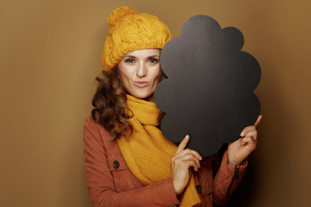 Hello autumn. Portrait of elegant woman in yellow beret and scarf showing cloud shape blank...