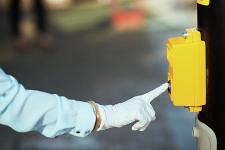 Life during coronavirus pandemic. Closeup on female in blue blouse with gloves pressing the traffic...