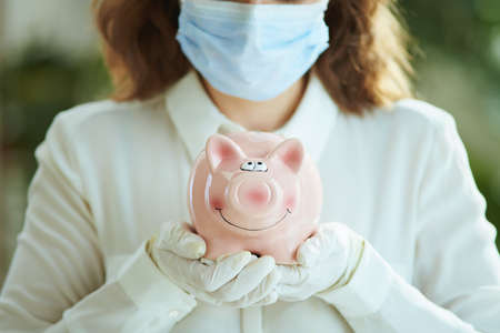 Life during covid-19 pandemic. Closeup on woman in white blouse disinfecting hands with sanitizer.の写真素材
