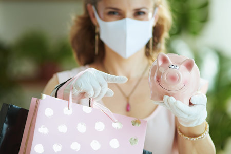 Life during coronavirus pandemic. Portrait of modern woman shopper in pink blouse with medical mask...
