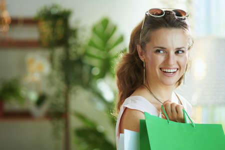 Portrait of happy trendy 40 years old woman shopper in pink blouse with credit card and paper shopping bags.の写真素材