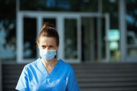 coronavirus pandemic. Closeup on medical doctor woman in scrubs with stethoscope and medical mask...