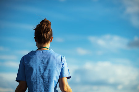 covid-19 pandemic. tired modern physician woman in scrubs with stethoscope, medical mask and rubber...