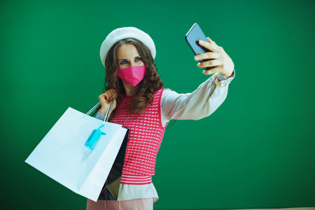 Life during covid-19 pandemic. Portrait of young woman shopper in pink sleeveless shirt with pink...