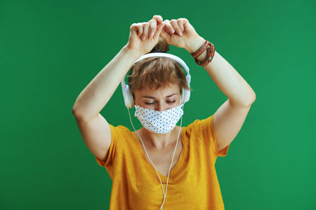 Life during coronavirus pandemic. Portrait of modern student woman in yellow shirt with medical...