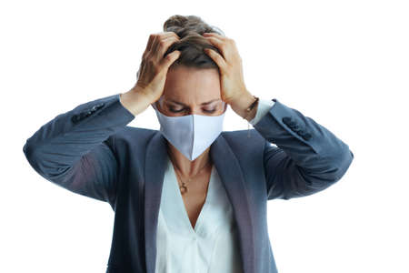 Business during covid-19 pandemic. Closeup on female in a grey suit with medical mask showing sanitiser isolated on white background.の写真素材