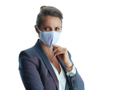 Business during covid-19 pandemic. Closeup on female in a grey suit with medical mask showing sanitiser isolated on white background.の写真素材