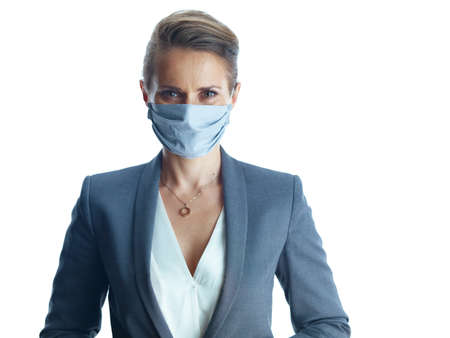 Business during covid-19 pandemic. Closeup on female in a grey suit with medical mask showing sanitiser isolated on white background.の写真素材