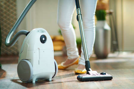 Closeup on woman with vacuum cleaner at home in sunny day.の写真素材