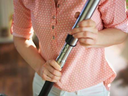 Closeup on woman with vacuum cleaner at home in sunny day.の写真素材