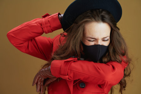 Hello autumn. young housewife in red coat with black mask, cup and paper shopping bags isolated on...