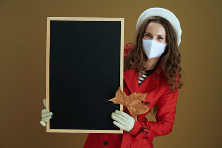 Life during coronavirus pandemic. Closeup on female in red coat sending text message using...