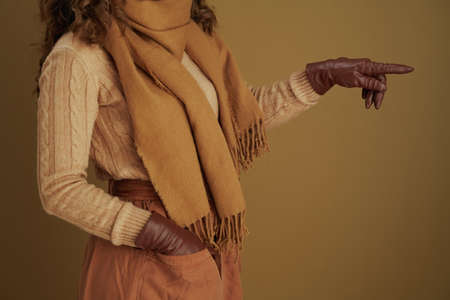 Hello autumn. happy stylish female in sweater with leather gloves and paper shopping bag against brown background.の写真素材