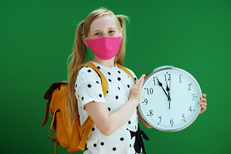 Life during coronavirus pandemic. Closeup on school girl in white polka dot blouse with yellow...