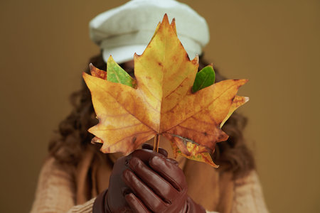 Hello october. Portrait of smiling trendy middle aged woman in scarf with leather gloves and paper...