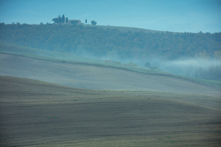landscape with agricultural field, hills and clouds in Tuscany, Italy in autumn at sunrise.の写真素材